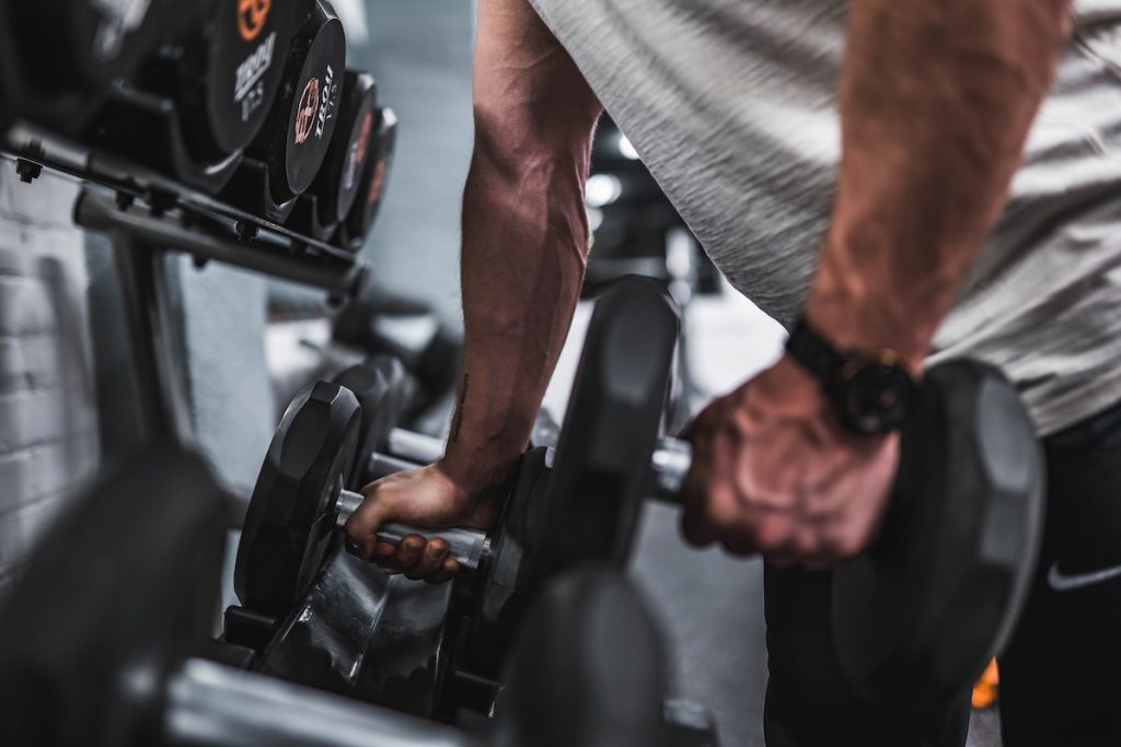 man grabbing dumbbells