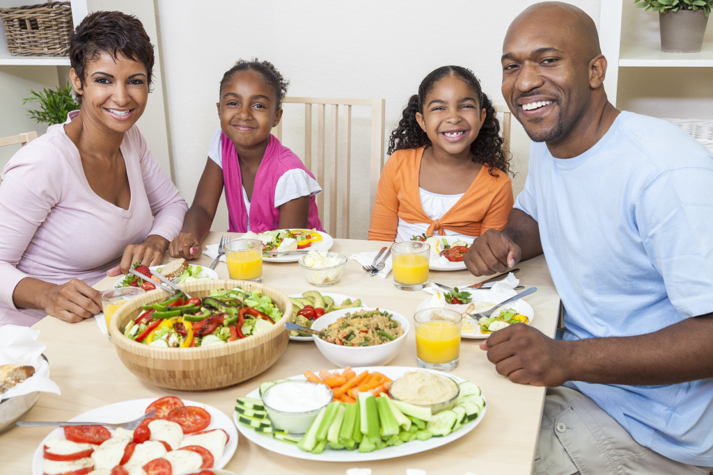 A family around a dinner table, with healthy food laid out