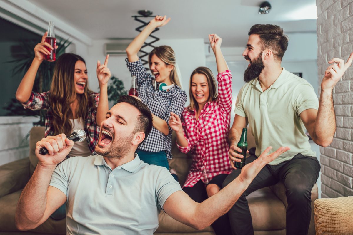 Group of friends playing karaoke at home. Concept about friendsh