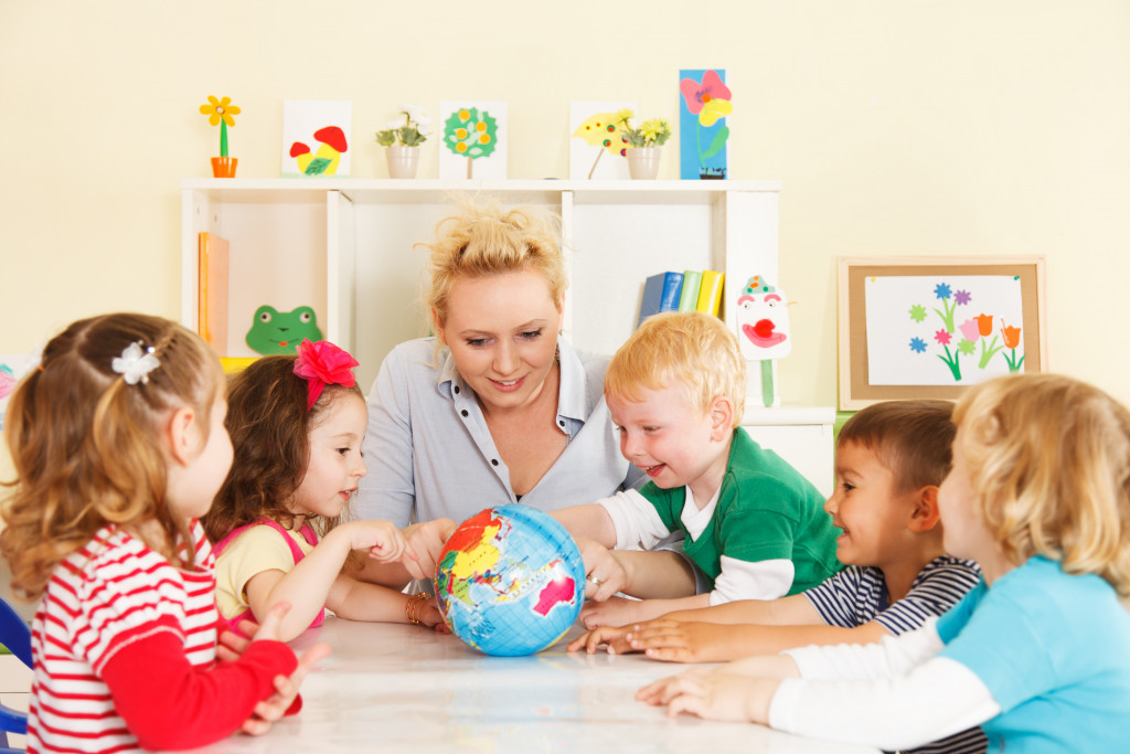 teacher with ittle kids in preschool
