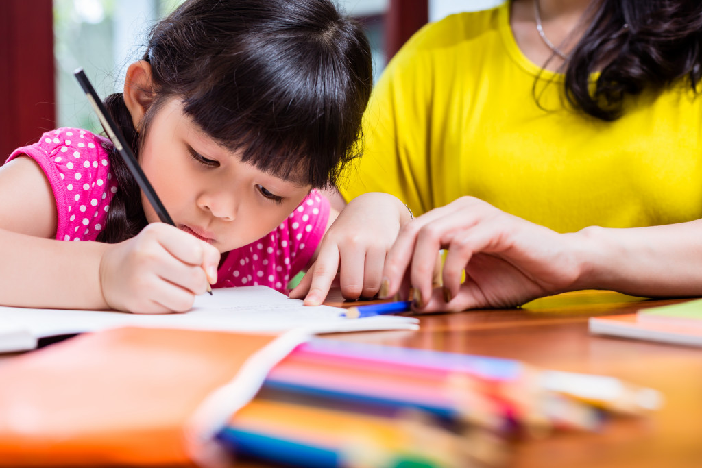 mom watching her daughter while drawing