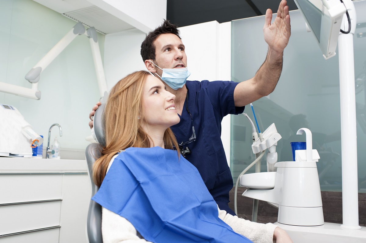 male dentist explaining to a female patient